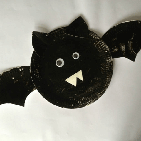 A crafted handmade bat made out of a paper plate painted black.