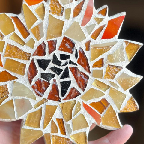 A close-up image of a colourful flower shaped mosaic tile.