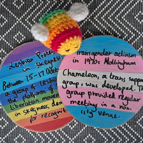 Two handmade circular plaques to commemorate LGBTQ+ figures in history.
