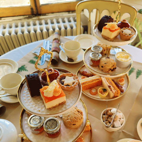 An Afternoon Tea set up with a selection of sandwiches and cakes on a table.
