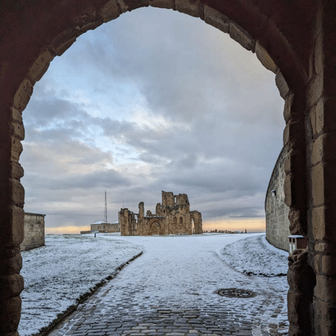 A view of Tynemouth Priory through an arch in the snow