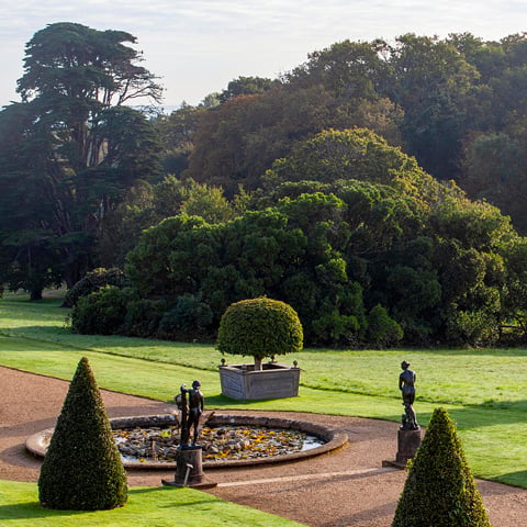 A view of the gardens at Osborne with the woodland in the background.