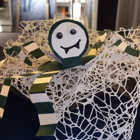 A close-up of a handmade paper spider halloween decoration.