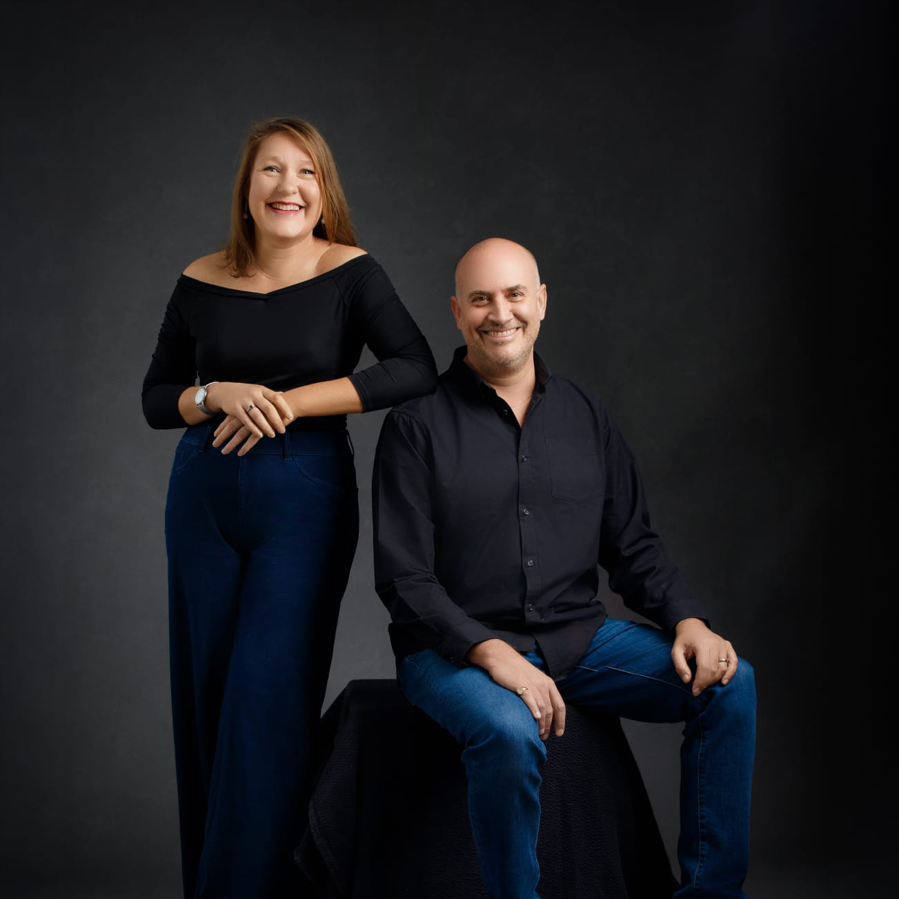 Jazz performers Hannar Brear and James Longford pose next to each other in front of a dark background.
