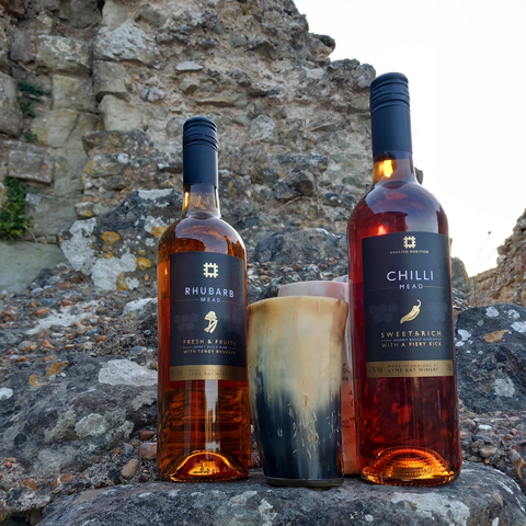 English Heritage wine bottles laid out on stone wall ruins.
