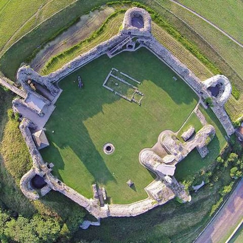 An aerial view of Pevensey Castle surrounded by fields.